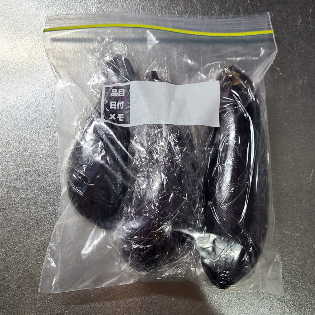 ラップで包んだナスを保存袋に入れる